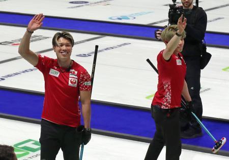 　カーリング世界選手権でイタリアに勝ち、声援に応える日本代表ＳＣ軽井沢クの山口（左）ら＝ムースジョー（共同）