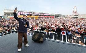 　ファンと一緒に自撮りをするレッドブルの角田裕毅（撮影・神子素慎一）