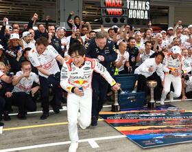 　記念撮影でレッドブルシャワーから逃げ出す角田裕毅（撮影・神子素慎一）