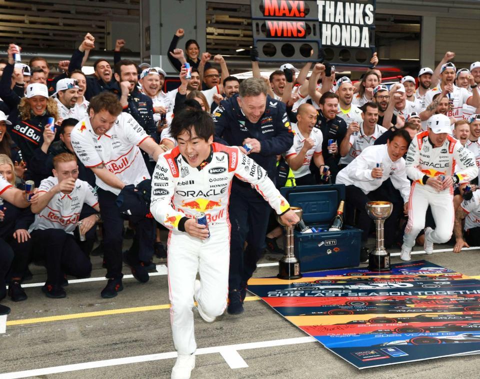 　記念撮影でレッドブルシャワーから逃げ出す角田裕毅（撮影・神子素慎一）