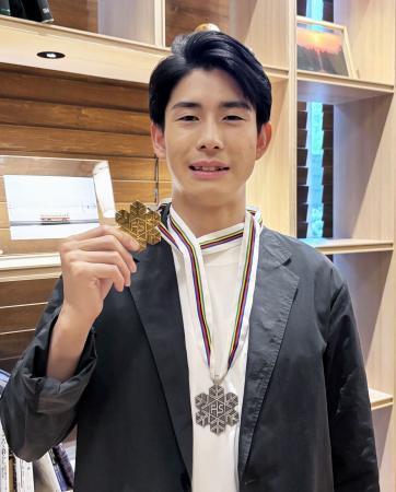 　フリースタイルスキーの世界選手権で獲得した金メダルを手にする男子モーグルの堀島行真＝２３日、東京都千代田区