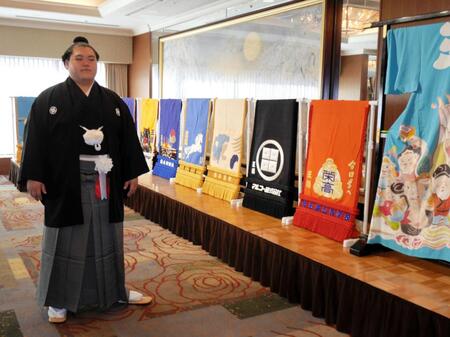 　これまでの化粧まわしを背に撮影に応じる王鵬