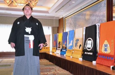 　新関脇昇進披露パーティーを前に、化粧まわしの前で記念撮影する王鵬＝２９日、東京都内