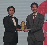 　プレゼンターの内田篤人氏から特別表彰を受けるサントリー・高橋藍（撮影・持木克友）