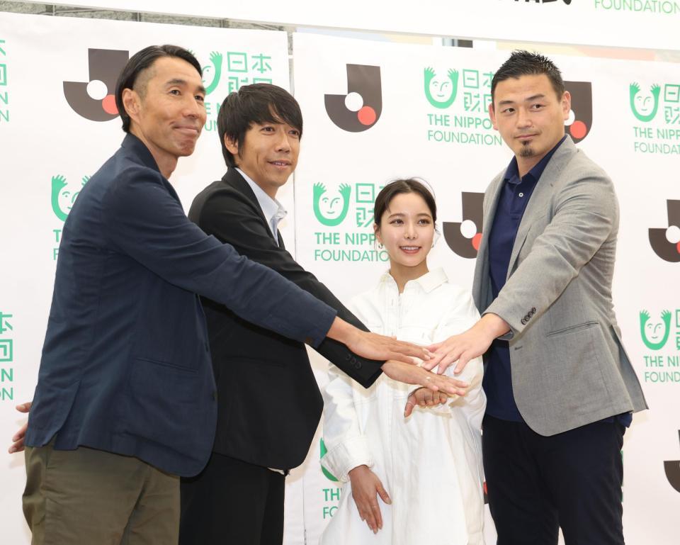 　手を重ねる（左から）Ｊリーグ・辻井隆行執行役員、同・中村憲剛特任理事、高梨沙羅、五郎丸歩氏（撮影・佐々木彰尚）