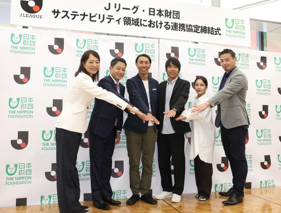 　手を重ねる（左から）井本直歩子氏、日本財団・笹川順平専務理事、Ｊリーグ・辻井隆行執行役員、同・中村憲剛特任理事、高梨沙羅、五郎丸歩氏（撮影・佐々木彰尚）