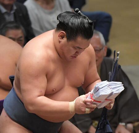 　懸賞の束を両手で持つ豊昇龍（撮影・佐藤厚）