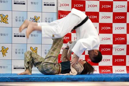 　警視庁の特殊詐欺防止啓発イベントで、ともえ投げを披露する角田夏実選手（下）＝３月２２日