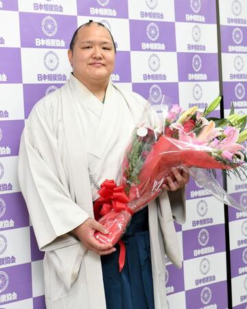 　穏やかな表情で花束を手にする北勝富士（撮影・佐藤厚）