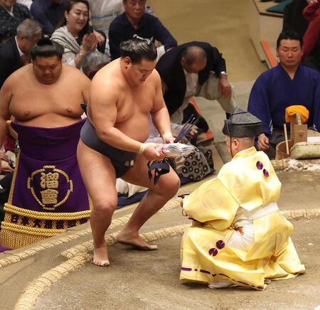　懸賞を手にする豊昇龍（撮影・佐々木彰尚）