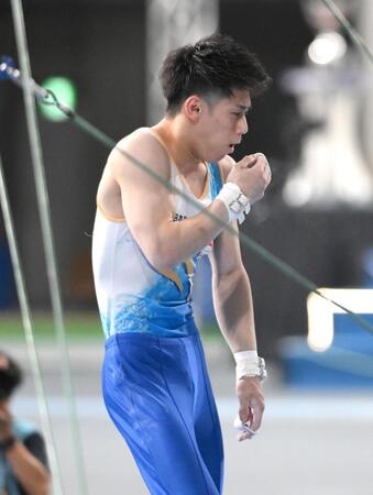 　鉄棒を終えて、滑り止めの粉が口に入り思わずせき込む橋本大輝（撮影・堀内翔）