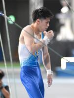 　鉄棒を終えて、滑り止めの粉が口に入り思わずせき込む橋本大輝（撮影・堀内翔）