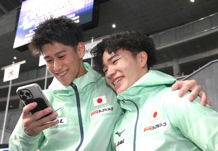 　記念撮影を終えてスマートフォンを確認する橋本大輝（左）と岡慎之助（撮影・堀内翔）