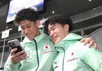 　記念撮影を終えてスマートフォンを確認する橋本大輝（左）と岡慎之助（撮影・堀内翔）