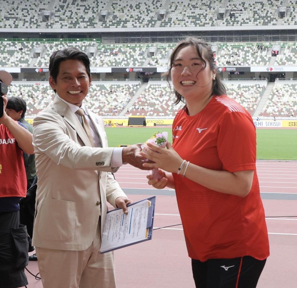 　織田裕二（左）から客席に投げ入れる花束を受け取る北口榛花