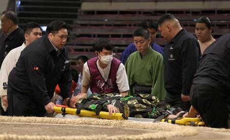 　担架で運ばれる行司の式守友三郎（撮影・佐々木彰尚）