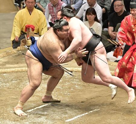 　飛び上がった千代翔馬（右）をガッチリ受け止める高安（撮影・持木克友）