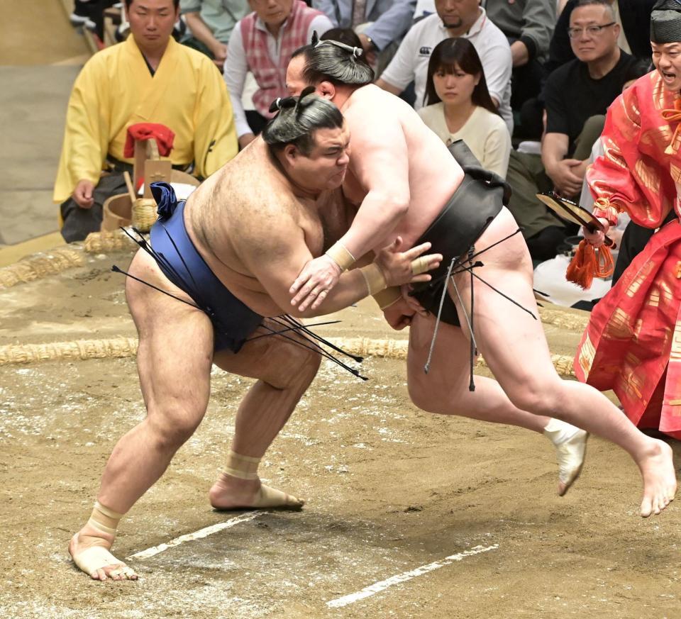 　飛び上がった千代翔馬（右）をガッチリ受け止める高安（撮影・持木克友）