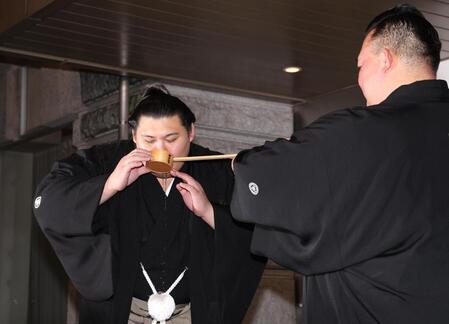 　二所ノ関親方（右）に水をつけてもらう大の里（撮影・佐々木彰尚）