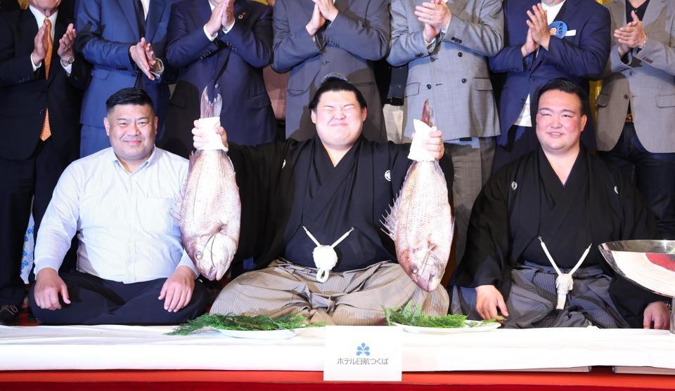 　父・中村知幸さん（左）、二所ノ関親方（右）が見守る中、鯛を手にする大の里（撮影・佐々木彰尚）
