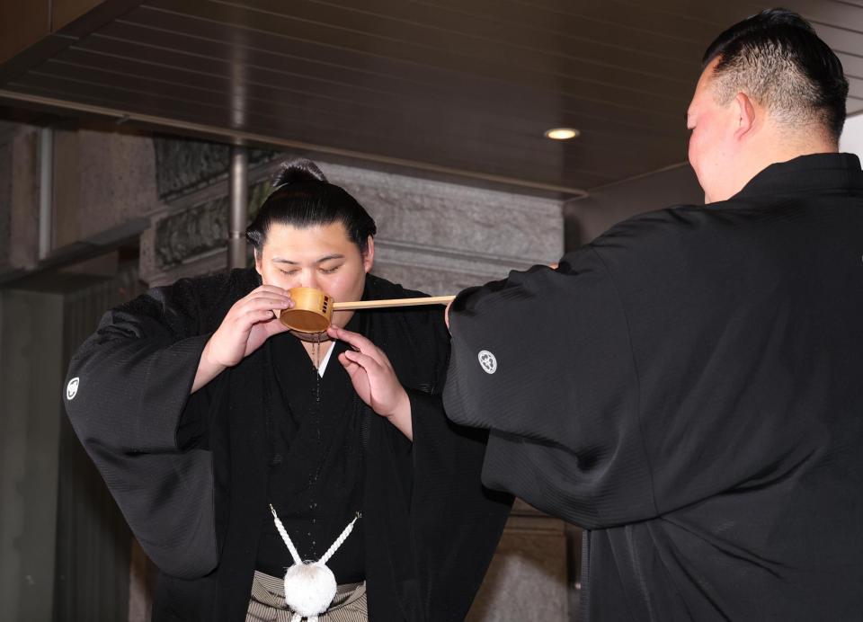 　二所ノ関親方（右）に水をつけてもらう大の里（撮影・佐々木彰尚）