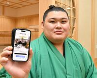 　デイリースポーツのホームページの写真を手にする大の里（撮影・持木克友）