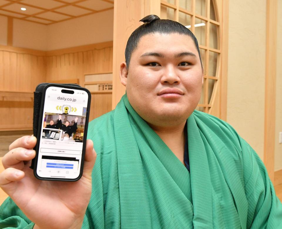 　デイリースポーツのホームページの写真を手にする大の里（撮影・持木克友）