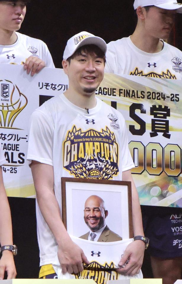　優勝セレモニーでケビン・ブラスウェル監督の遺影を手にする宇都宮の比江島