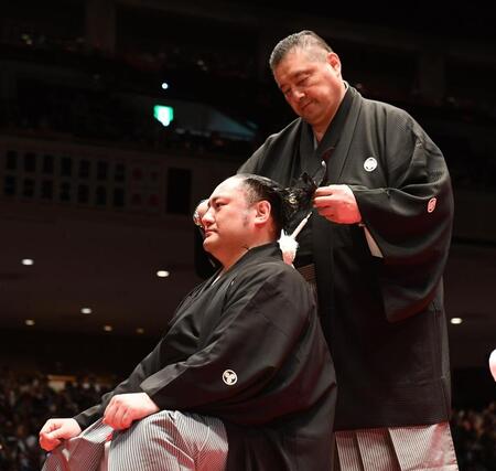 　佐渡ケ嶽親方（右）に大銀杏（おおいちょう）落とされる琴恵光（撮影・園田高夫）