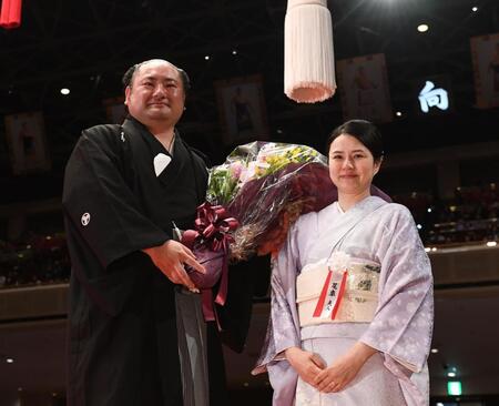 　奥さんの由香利夫人（右）から花束を渡される元琴恵光の尾車親方（撮影・園田高夫）