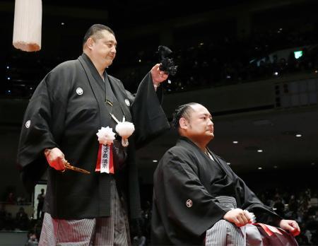 　引退相撲の断髪式で佐渡ケ嶽親方に最後のはさみを入れられ、大銀杏を切り落とした元幕内琴恵光の尾車親方＝３１日、両国国技館