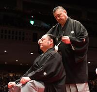 　佐渡ケ嶽親方（右）に大銀杏（おおいちょう）落とされる琴恵光（撮影・園田高夫）