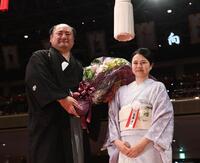 　奥さんの由香利夫人（右）から花束を渡される元琴恵光の尾車親方（撮影・園田高夫）