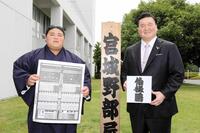 　新入幕を果たし、番付を持つ伯桜鵬（左）としこ名を書いた色紙を持つ宮城野親方＝２３年６月