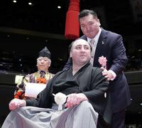 　はさみを入れた宮城野親方（右）からねぎらわれる栃ノ心＝２０２４年２月