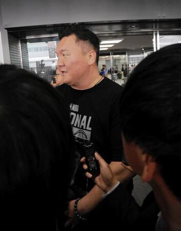 　モンゴルからの航空機で日本に到着し、報道陣に囲まれる宮城野親方