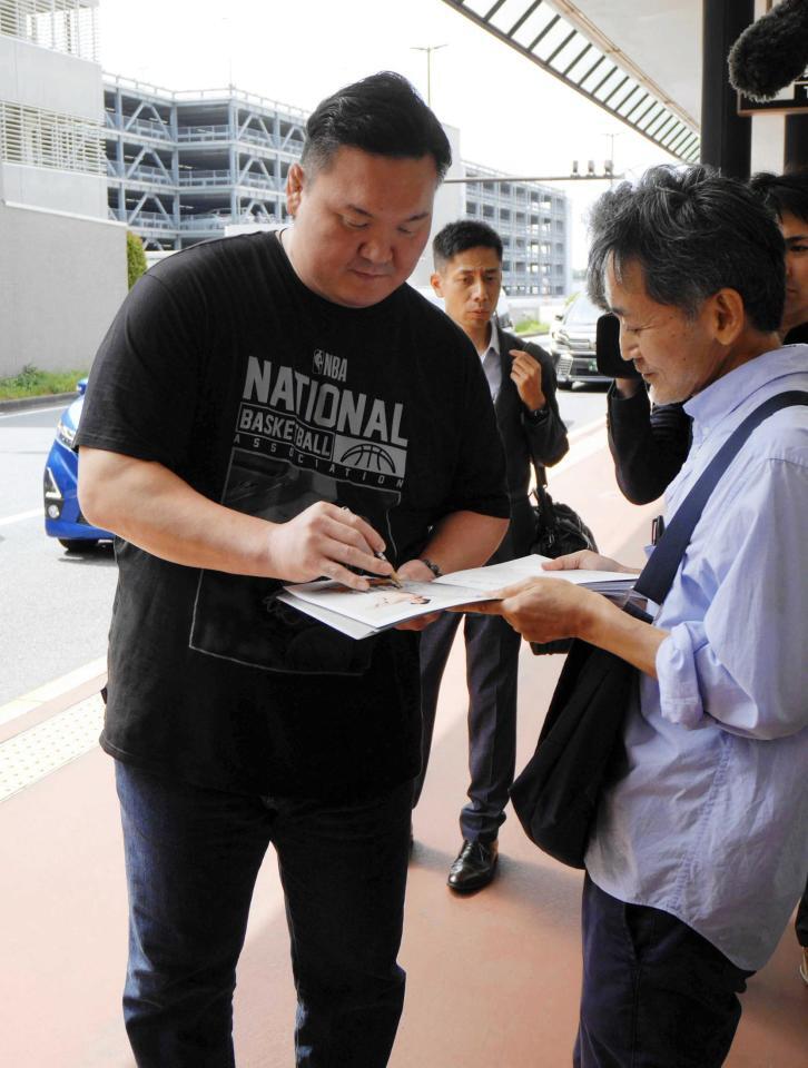 　成田空港に到着し、ファンにサインを求められる宮城野親方