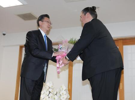 　宮城野親方（左）に花束を渡す伊勢ケ浜親方（撮影・西岡正）