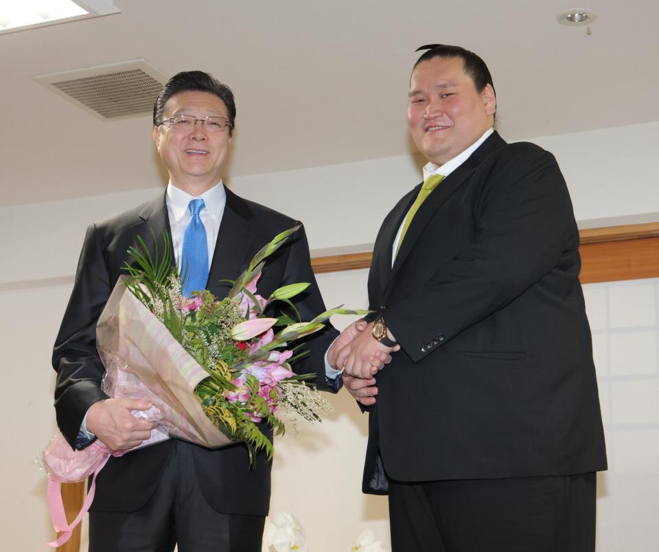 　宮城野親方（左）と笑顔で握手する伊勢ケ浜親方（撮影・西岡正）