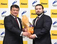 　パーク２４柔道部・吉田秀彦総監督（左）から花束を渡され笑顔を見せるウルフ・アロン（撮影・佐藤厚）