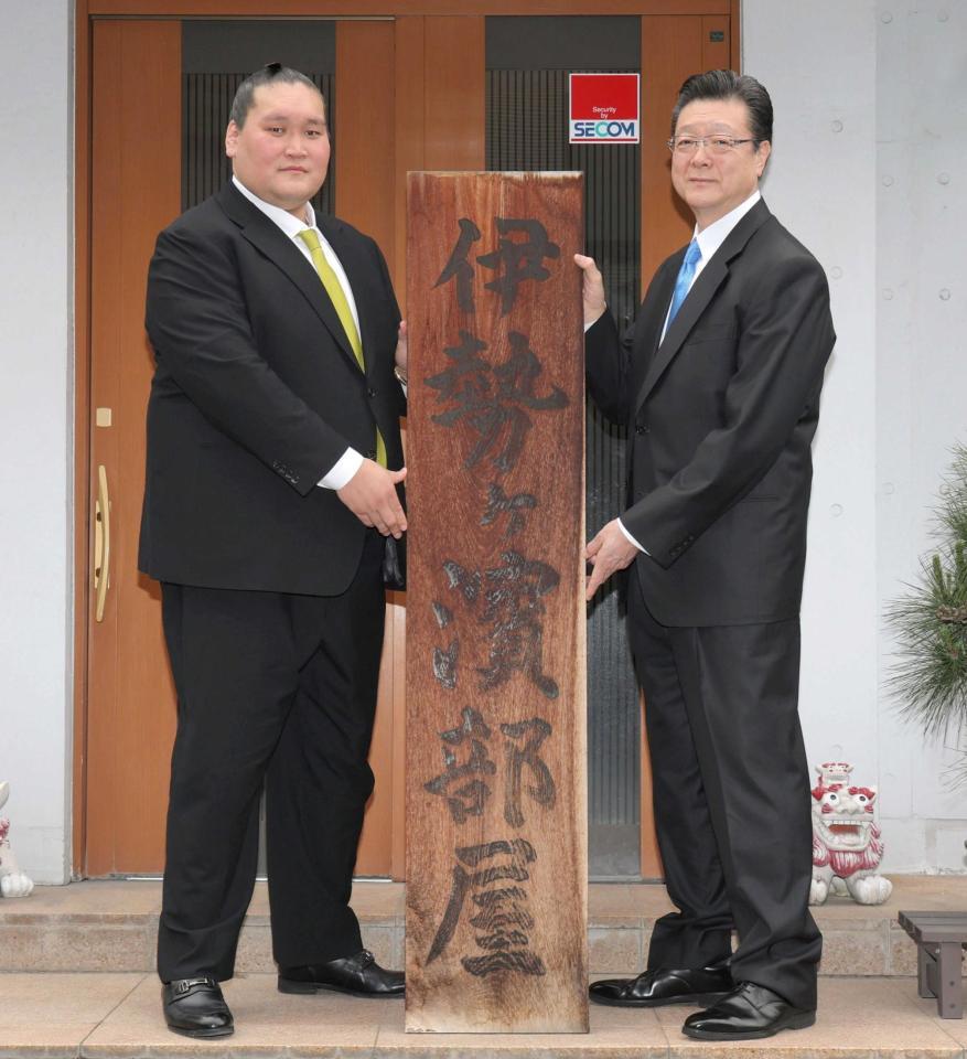 　伊勢ケ浜部屋の看板を持つ伊勢ケ浜親方（左）と宮城野親方（撮影・西岡正）