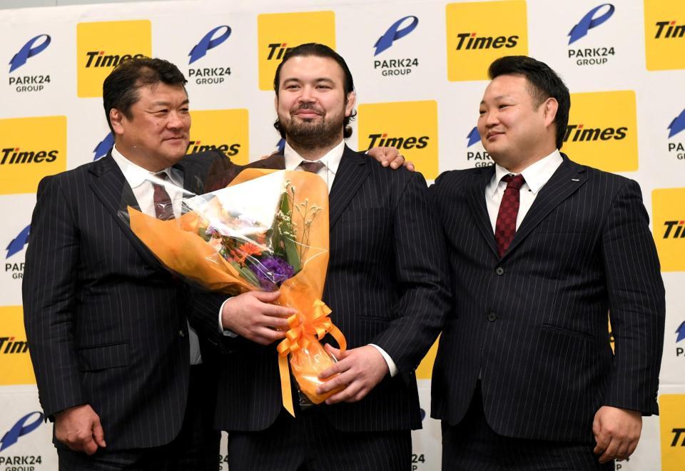 　パーク２４柔道部・吉田秀彦総監督（左）と海老沼聖男子監督（右）から肩を抱かれ照れ笑いを浮かべるウルフ・アロン（撮影・佐藤厚）