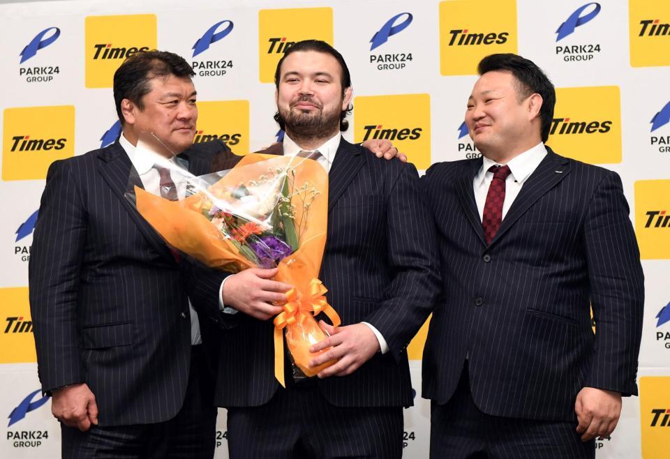 　パーク２４柔道部・吉田秀彦総監督（左）と海老沼聖男子監督（右）から肩を抱かれ照れ笑いを浮かべるウルフ・アロン（撮影・佐藤厚）