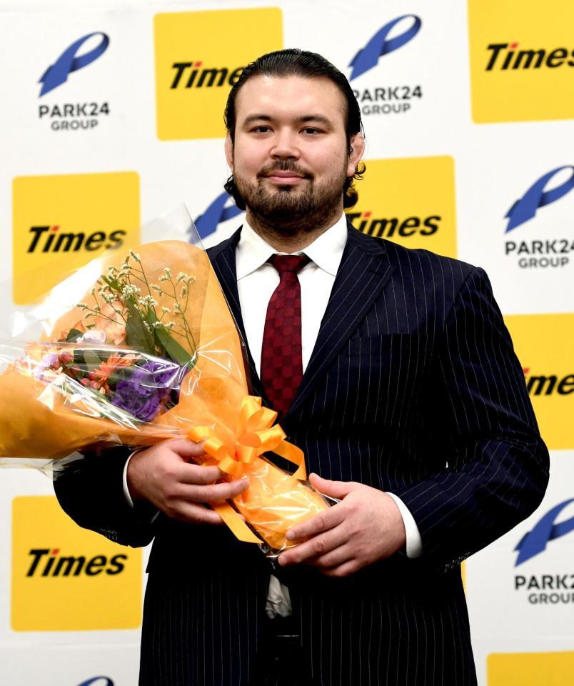 　花束を手に笑顔を見せるウルフ・アロン（撮影・佐藤厚）