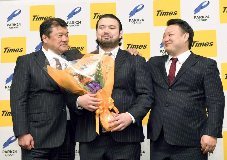 　パーク２４柔道部の吉田総監督（左）と海老沼男子監督（右）から肩を抱かれ、照れ笑いを浮かべるウルフ・アロン（撮影・佐藤厚）