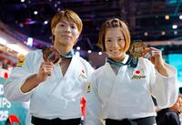 　女子52キロ級で５度目の優勝を果たし、金メダルを手に笑顔の阿部詩。左は男子66キロ級で銅メダルの兄、阿部一二三（共同）