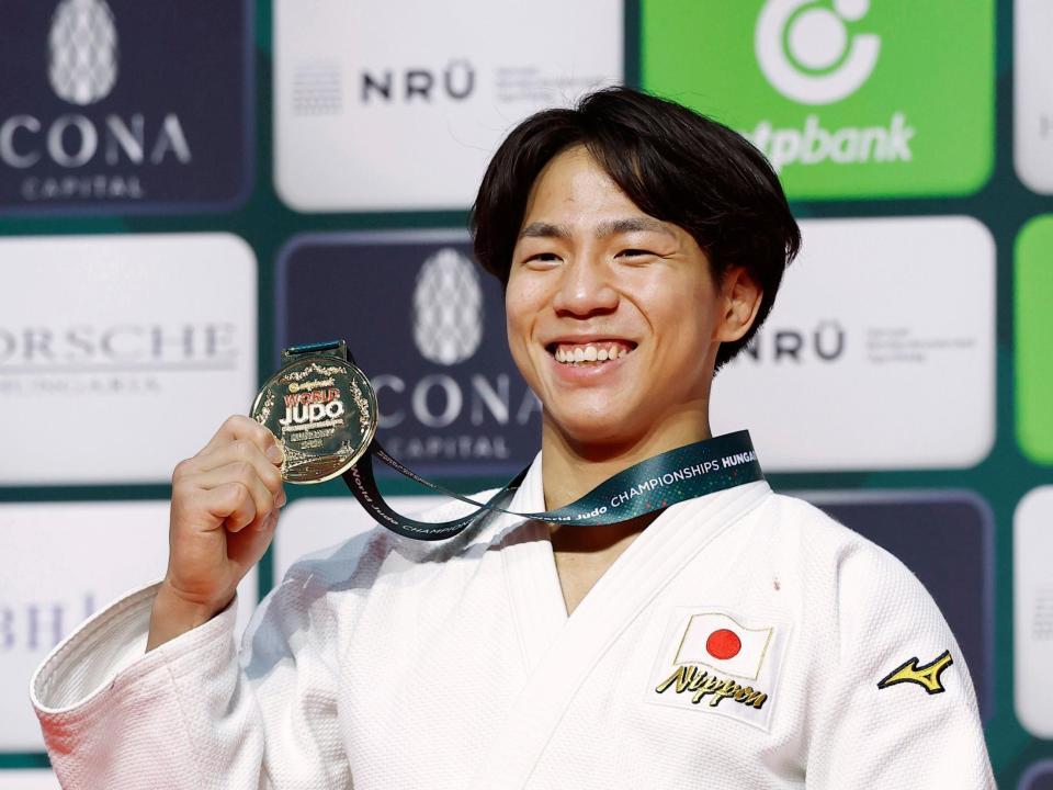 　男子66キロ級で初優勝を果たし、金メダルを手に笑顔を見せる武岡毅（共同）