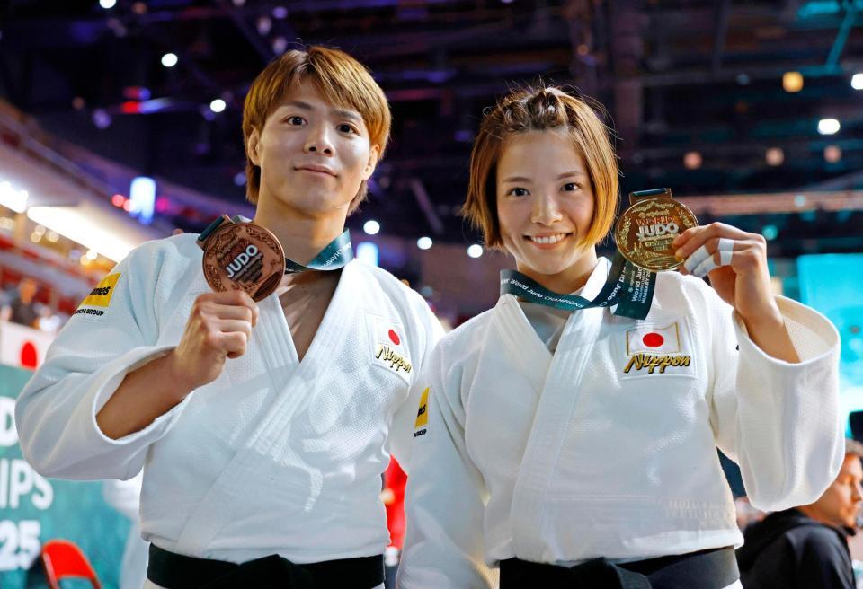 　女子52キロ級で５度目の優勝を果たし、金メダルを手に笑顔の阿部詩。左は男子66キロ級で銅メダルの兄、阿部一二三（共同）