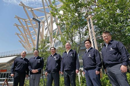 　大相撲名古屋場所の開催を知らせる「御免札」を新会場となるＩＧアリーナ（奥）に設置した出羽海担当部長（右から３人目）ら＝１８日、名古屋市