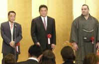 　壇上で友人の桂きん枝（左端）から激励を受ける三保ヶ関親方（中央）と阿覧＝２０１３年